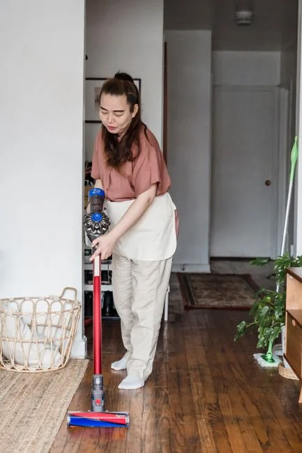 Two cleaning professionals standing back to back in uniform, ready for work.